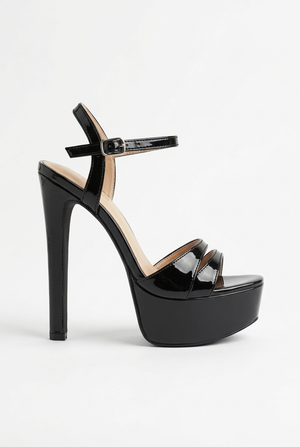 Clean studio profile of the black patent platform sandal