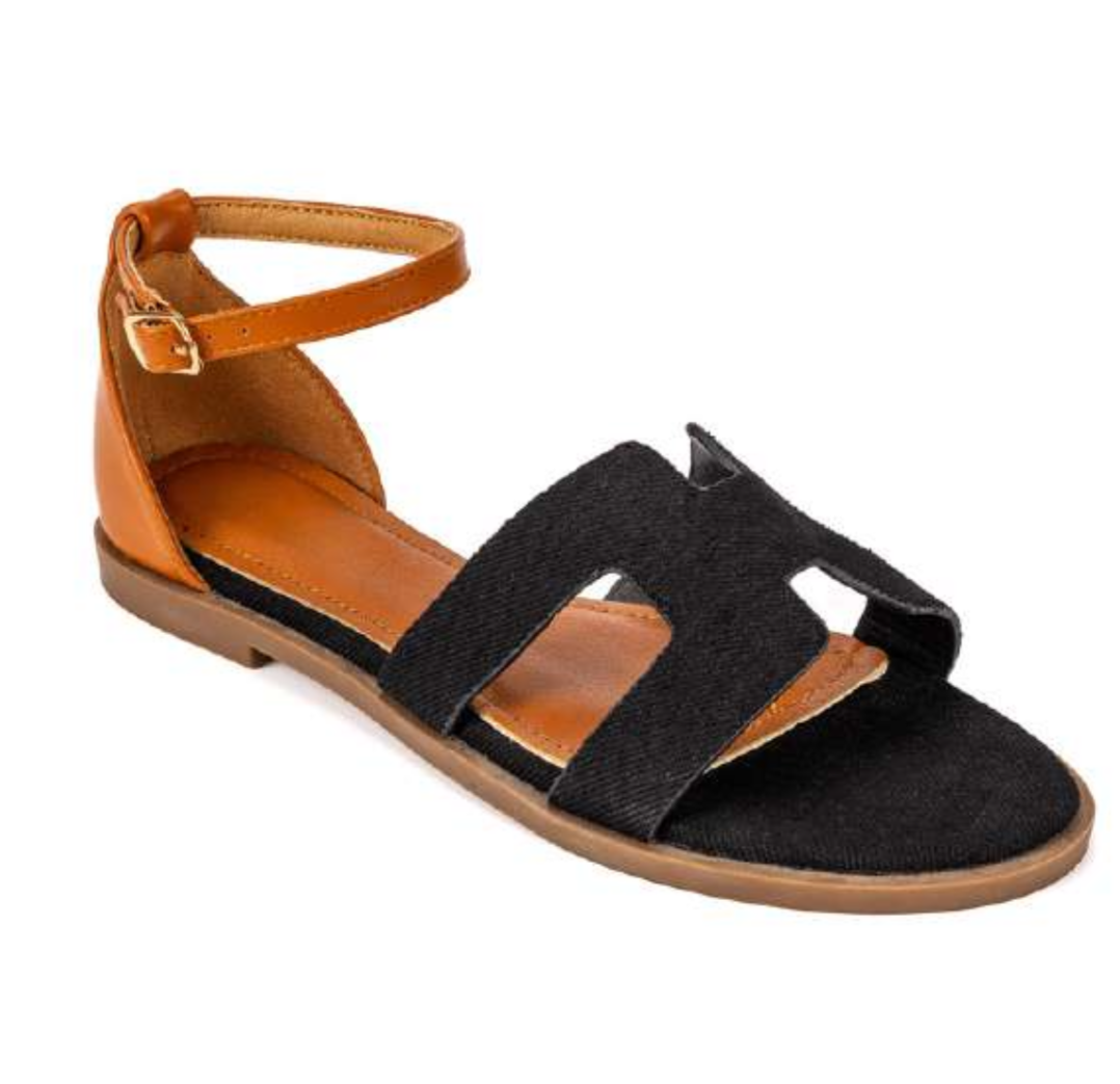 Edmond Black Suede H-Strap Flat Sandals – product shot showing black suede H-strap upper with tan leather ankle strap and gold buckle on warm tan leather footbed