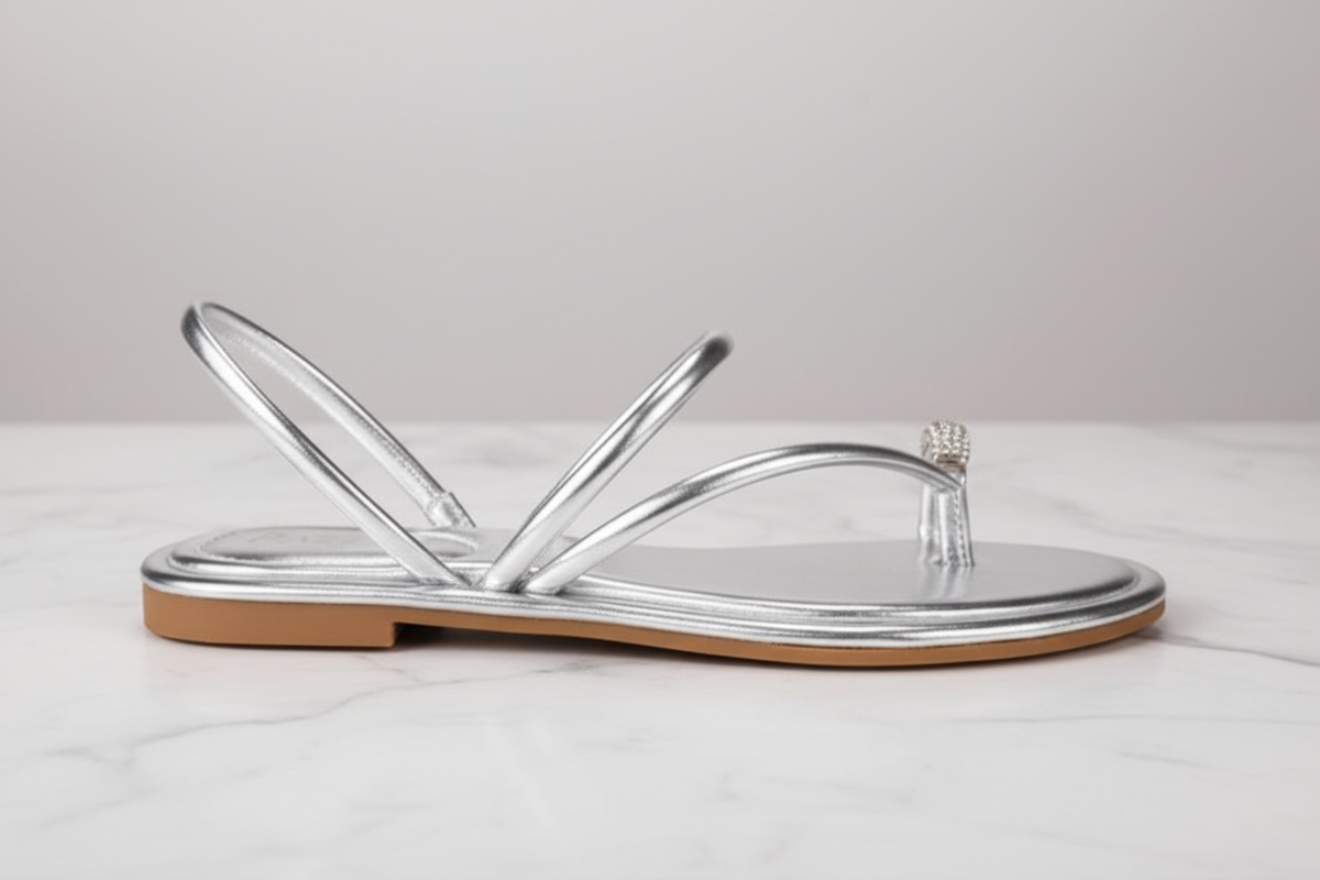 Nora Silver Metallic Crystal Toe Ring Flat Sandals – side profile view on white marble