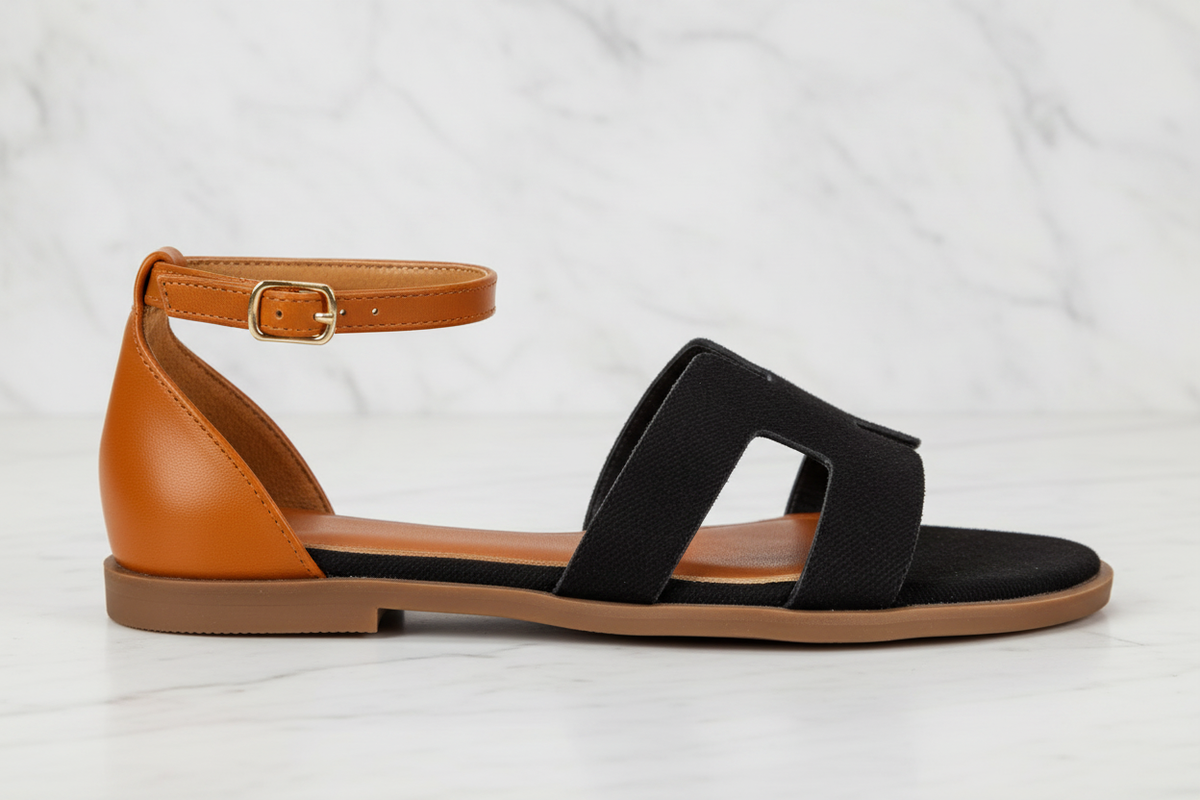 Edmond Black Suede H-Strap Flat Sandals – side profile view on white marble showing H-strap and ankle strap