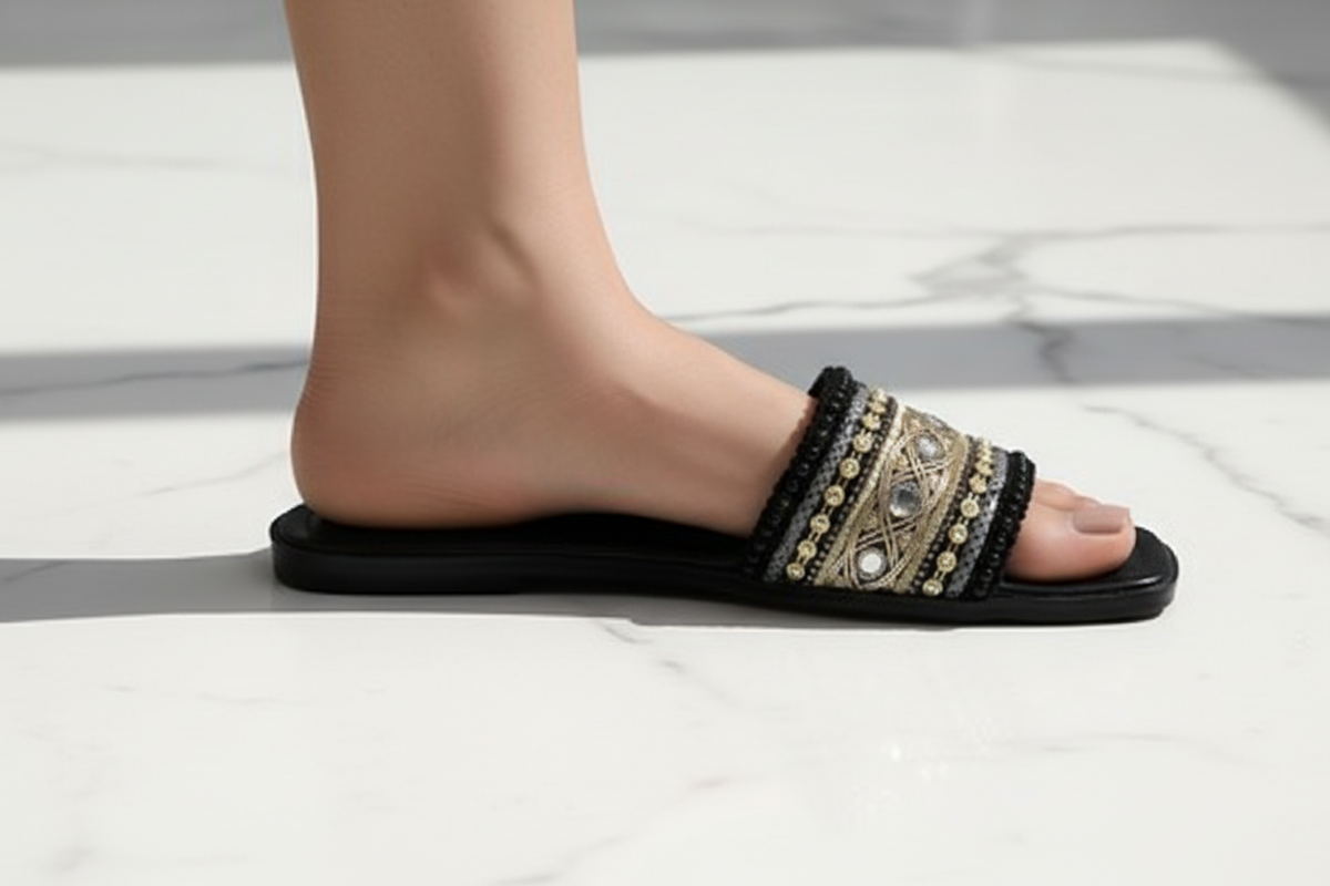 Black Gold Embroidered Crystal Flat Slide Sandals – ground level profile hero shot showing gold embroidery and crystal jewel detail mid-stride