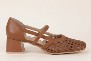Close-up profile of woven tan Mary Jane shoe with gold buckle⠋